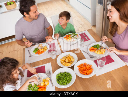 Famiglia sorridente attorno ad un pasto sano Foto Stock