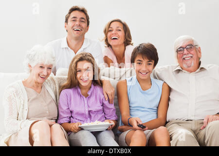 Famiglia multigenerazionali sul lettino di guardare la tv Foto Stock