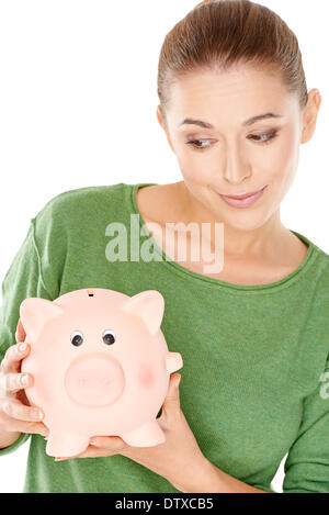 Donna dando il suo salvadanaio un aspetto speculativo Foto Stock