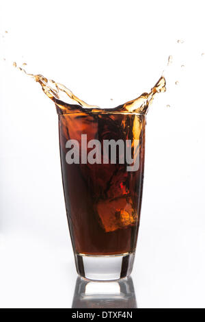 Il cubo di ghiaccio cadere nel bicchiere di soda Foto Stock