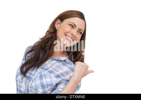 Giovane donna che mostra qualcosa dietro di lei Foto Stock