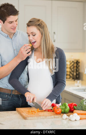 L'uomo alimentazione di sua moglie incinta Foto Stock