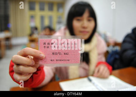 Changsha, provincia cinese di Hunan. 24 Febbraio, 2014. Uno studente mostra la sua scheda sedile nella libreria di Hunan Normal University di Changsha, capitale della centrale provincia cinese di Hunan, Feb 24, 2014. La biblioteca fornisce tre camere per gli studenti che si preparano a prendere gli esami post-laurea. Le sedi delle camere sono distribuite ai collegi sulla base delle loro esigenze. Gli studenti possono ottenere una sede attraverso la sede di lottery della scheda o la condivisione di una sede con gli altri. Il nuovo modo di assegnazione posto gli studenti fa risparmiare tempo e riduce il rozzo comportamento. © Li Ga/Xinhua/Alamy Live News Foto Stock