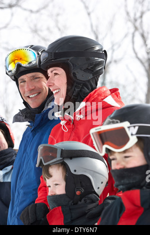 Famiglia caucasica indossando attrezzatura da sci nella neve Foto Stock