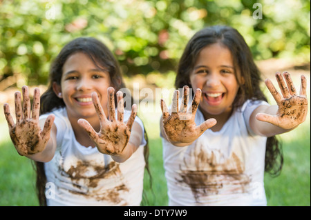 Razza mista ragazze coperto di fango all'aperto Foto Stock