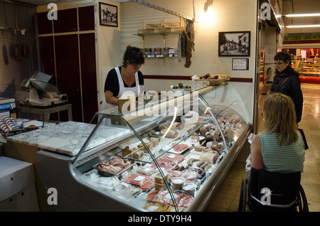 Una donna su una sedia a rotelle acquisto di cibo in un mercato in Francia Foto Stock