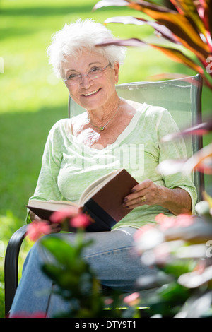 Senior donna caucasica libro lettura all'aperto Foto Stock