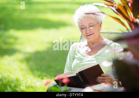 Senior donna caucasica libro lettura all'aperto Foto Stock