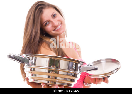 Bella giovane donna cercando di essere casalinga con pentola pentola in cucina Foto Stock