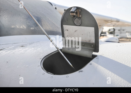 Pilota di eseguire una verifica di preflight su un Cessna skyhawk controllo dell'olio con un'astina di livello Foto Stock