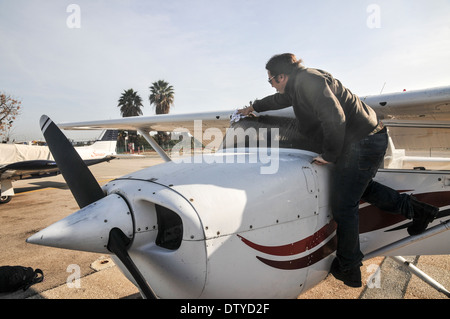 Pilota di eseguire una verifica di preflight su un Cessna skyhawk Foto Stock