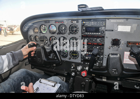 Pilota di eseguire una verifica di preflight su un Cessna skyhawk all'interno del cockpit Foto Stock