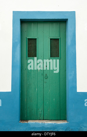 Il verde di porte in legno in azzurro e bianco muro, Portogallo Foto Stock