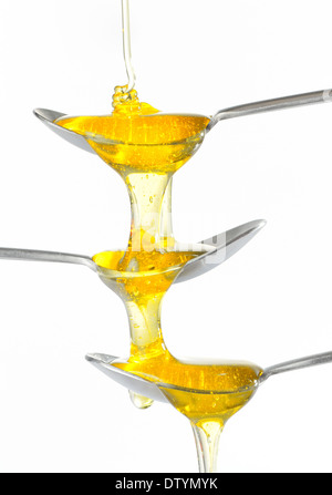 Il miele dorato di flusso e cucchiaio Foto Stock