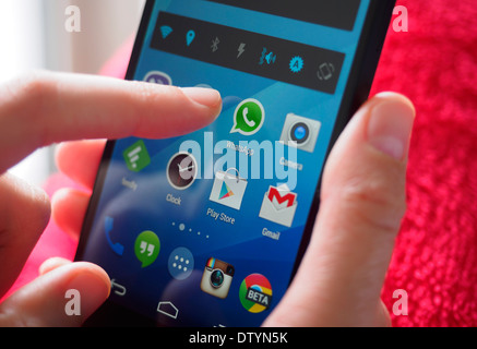 Persona in possesso di smartphone con WhatsApp app di messaggistica Foto Stock