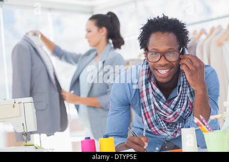 Sorridente designer di moda sul telefono Foto Stock