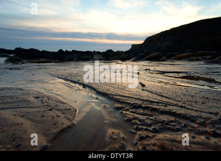 Luce dorata in modelli in sabbia a Saltwick Bay Whitby, North Yorkshire England Regno Unito Foto Stock