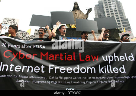 Manila, Filippine, . 25 feb 2014. Manifestanti holding nero schede di carta come una protesta della presunta riduzione della libertà di parola mediante la legge sulla criminalità informatica durante il martedì nero dimostrazione presso il Santuario di Edsa in Quezon City. -- Supporti diversi gruppi, insieme con gli studenti attivisti, commemorato il 28° anniversario della Rivoluzione Edsa con un rally di protesta contro la legge sulla criminalità informatica. Credito: J Gerard Seguia/NurPhoto/ZUMAPRESS.com/Alamy Live News Foto Stock