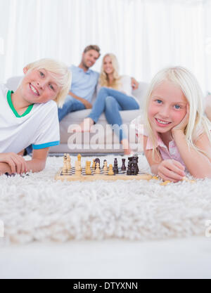 Bambini giacente su un tappeto o giocare a scacchi Foto Stock