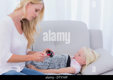 Mom dando sua figlia di medicina Foto Stock