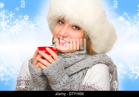 Ragazza giovane con la tazza su sfondo inverno Foto Stock