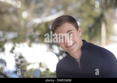 Ragazzo adolescente in inverno all'aperto con un sfondo innevato Foto Stock