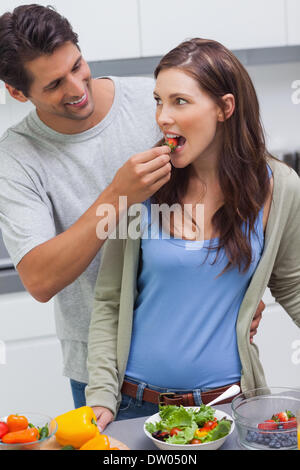 L'uomo alimentando la moglie di pomodoro ciliegino Foto Stock