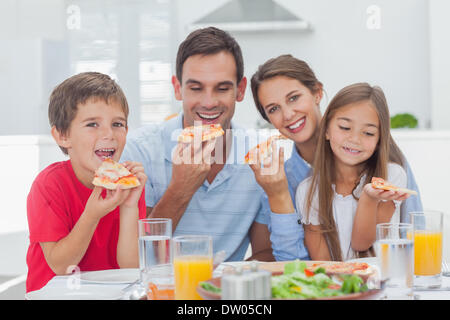 Famiglia mangiare fette di pizza Foto Stock