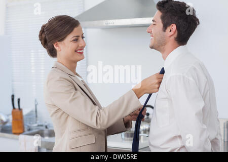 Donna aiutando il marito a legare il suo tirante Foto Stock