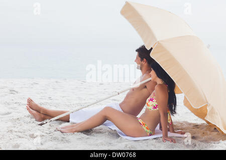 Giovane sdraiato sul telo mare in spiaggia Foto Stock