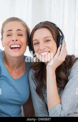 Donne che ridono ascoltando musica Foto Stock