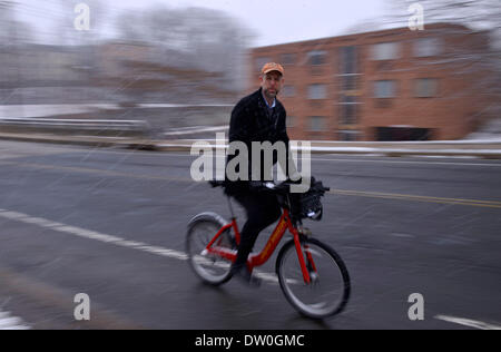 Washington DC, Stati Uniti d'America. 25 feb 2014. Un uomo che cavalca una bicicletta durante una nevicata in Arlington, il Virginian, negli Stati Uniti, febbraio 25, 2014. Credito: Yin Bogu/Xinhua/Alamy Live News Foto Stock