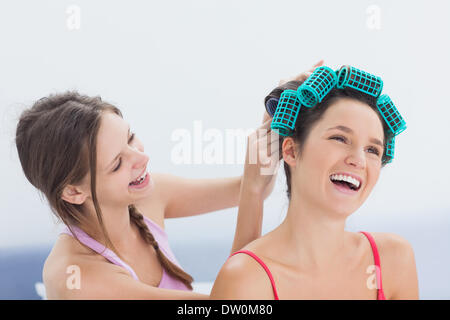 Ragazza che fissa i suoi amici i capelli rulli Foto Stock