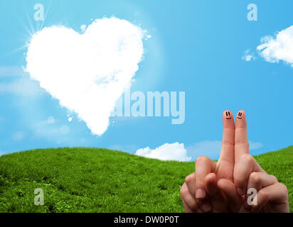 Faccina felice dita guardando a forma di cuore ad cloud Foto Stock