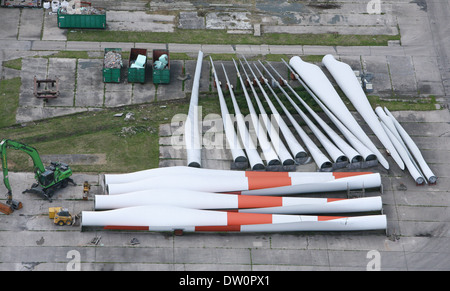 Foto aerea gigante di pale per turbine eoliche giacente in una fila sul terreno. Foto Stock