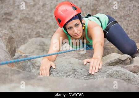 Determinata ragazza arrampicata roccia Foto Stock