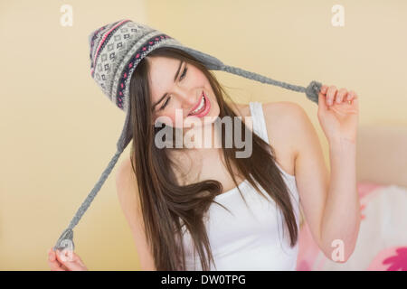 Silly Pretty girl cercando su un cappello di lana Foto Stock