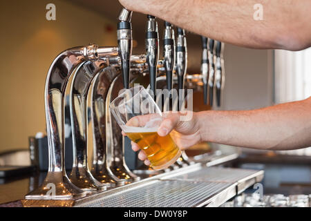 Man mano a versare birra Foto Stock