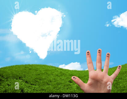 Faccina felice dita guardando a forma di cuore ad cloud Foto Stock