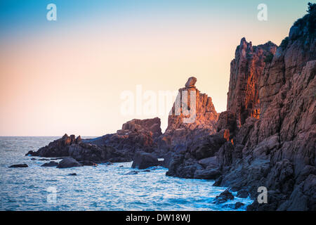 Sunrise luce che risplende sulla barriera corallina rock Foto Stock