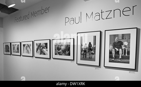 Il lavoro di un fotografo è visualizzato sulla parete di una galleria. Foto Stock