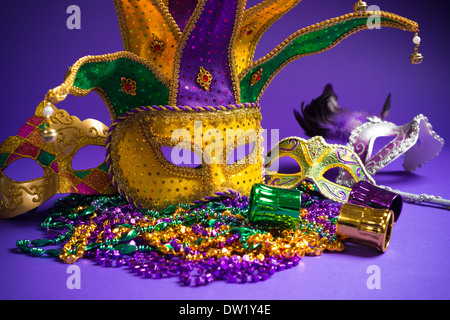 Raggruppamento di festa del Mardi Gras, veneziano o carnivale maschera su uno sfondo viola Foto Stock