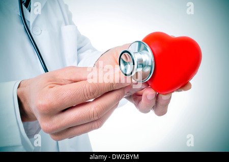 Un medico auscultating un cuore rosso con uno stetoscopio Foto Stock