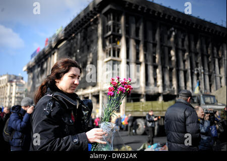(140226) -- KIEV, Feb 26, 2014 (Xinhua) -- una donna si prepara a deporre un mazzo di fiori per piangere le vittime degli scontri di piazza Indipendenza a Kiev, capitale dell'Ucraina, nel febbraio 24, 2014. (Xinhua/Dai Tianfang) Foto Stock