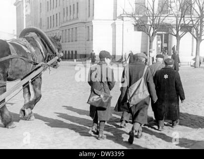 Gli ebrei camminano lungo una carrozza trainata da cavalli su una strada nel ghetto di riga. Scena da riga (Lettonia) al momento dell'occupazione tedesca dal 1941 al 1944. Dopo la conquista di riga da parte della Wehrmacht tedesca, il comando di occupazione di riga decise di concentrare i lavoratori ebrei in un ghetto il 21 luglio 1941. Tutti gli ebrei furono registrati e dovettero indossare una Stella di Davide, anche loro non poterono usare i marciapiedi. Fotoarchiv für Zeitgeschichtee / NESSUN SERVIZIO DI CABLAGGIO Foto Stock