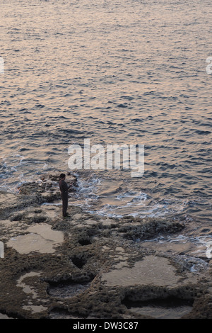 L'uomo la pesca al tramonto in acri, Akko, Israele Foto Stock