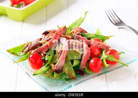 Strisce di arrosto di manzo sul nido di verdure saltati Foto Stock