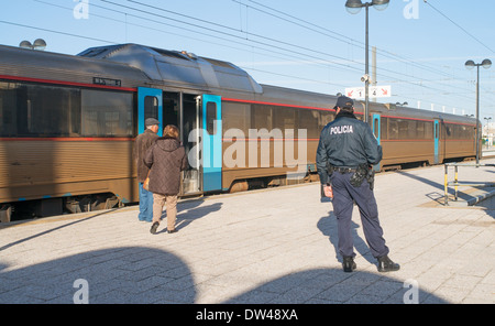 Un funzionario di polizia a guardare la gente a bordo di un treno in stazione ferroviaria di Faro, Algarve, Portogallo, Europa Foto Stock