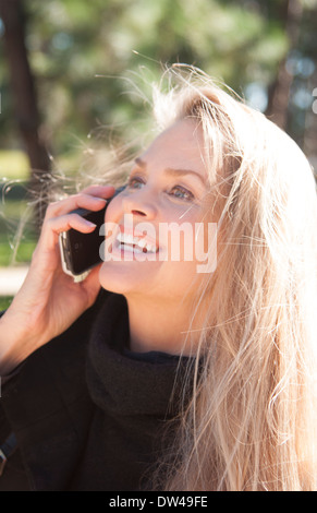 Giovani attraenti 50 anno vecchia donna parlando al cellulare all'aperto sorridente ancora bella anche nel medioevo Foto Stock