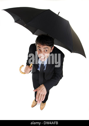 Divertente angolo alto a piena lunghezza Ritratto di un imprenditore rifugiandosi sotto il suo ombrello di controllo del sensore pioggia Foto Stock